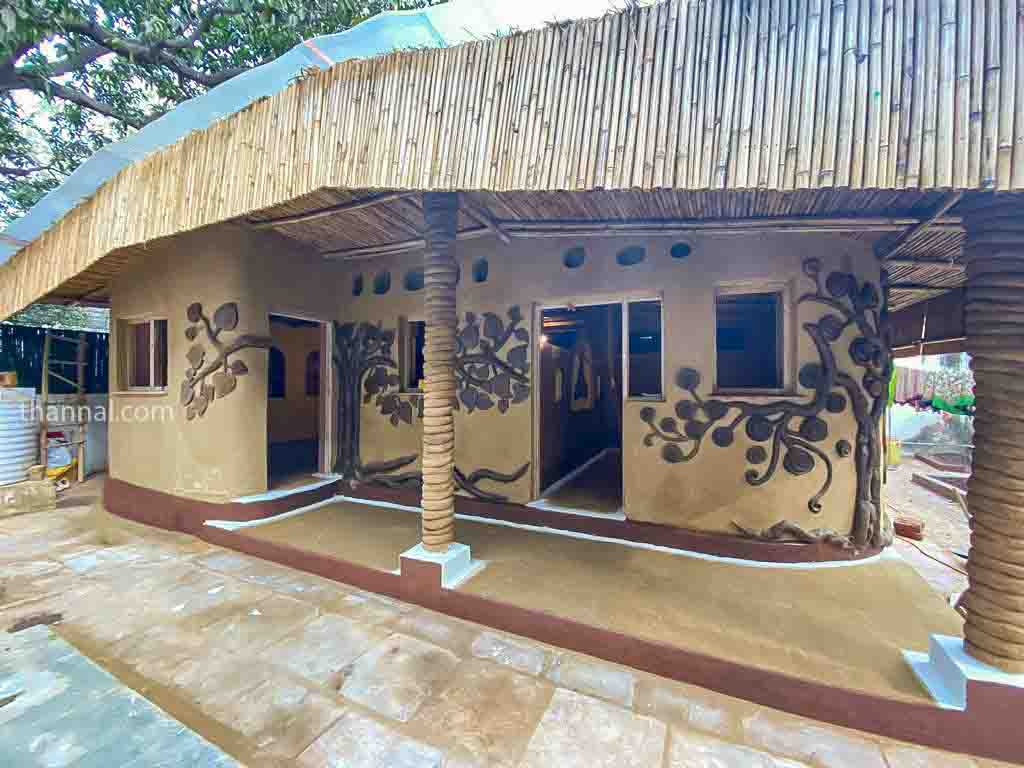 Sun dried Adobe mud home with sculptures and bamboo in Delhi India