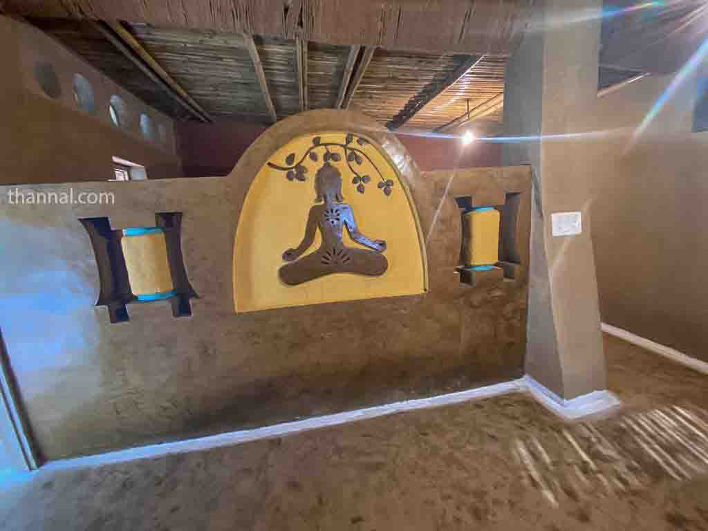 Living Space with Adobe bench and 3D wall sculpture inside mud house